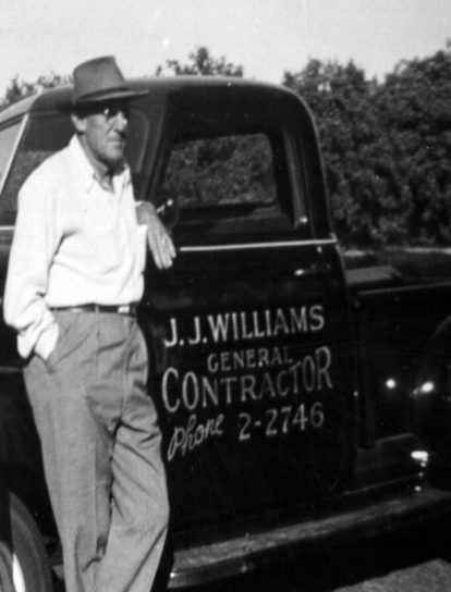 old photo of a man standing next to a vehicle