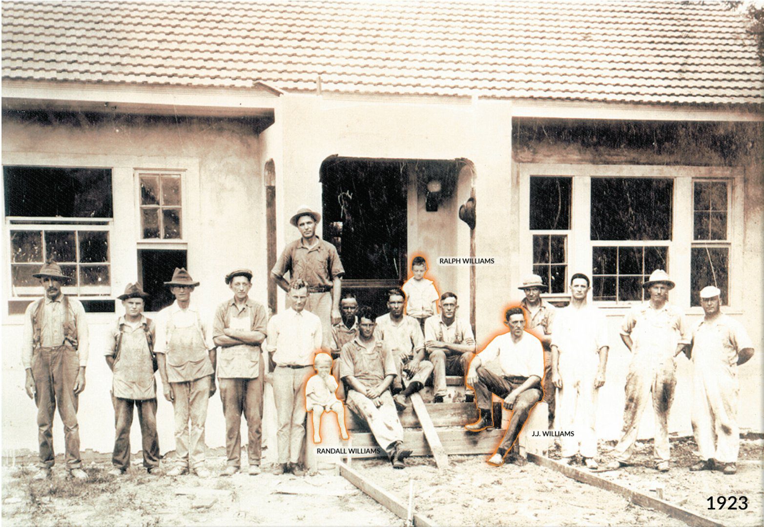 Black and white photo of a group of men building a house in 1923.