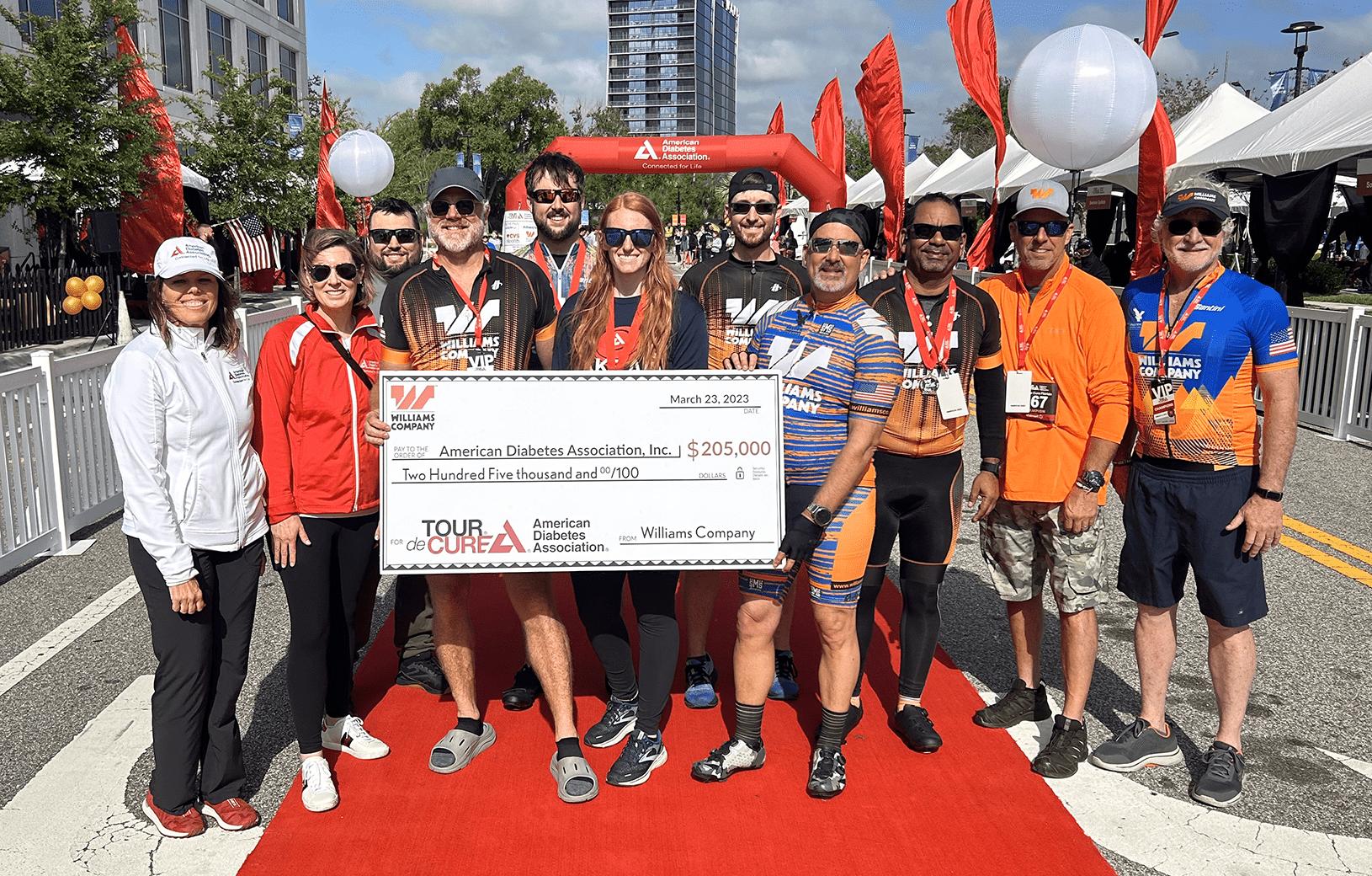 A group of cyclists posing for a photo at a charity event.