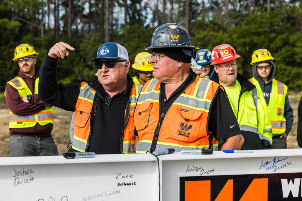 Workers in safety gear discussing at a construction site.
