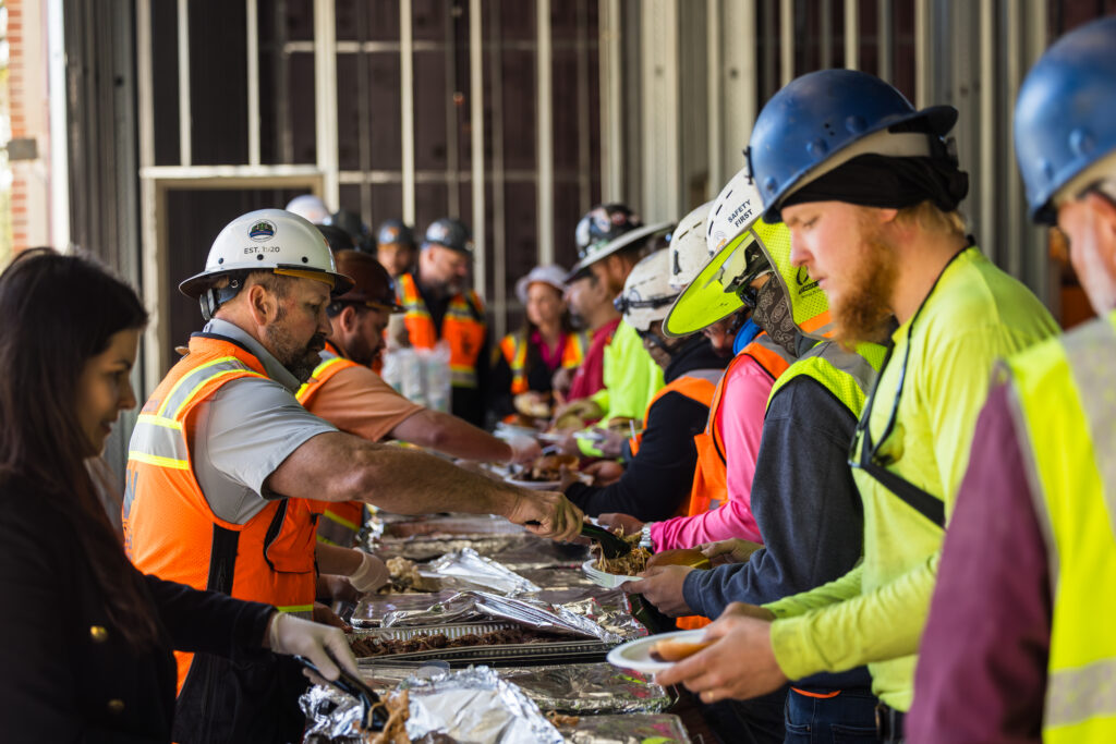 Volunteers serve food to people in a community setting.