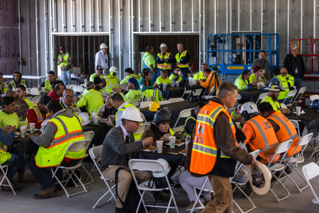 Construction workers in safety gear having a meeting at a construction site.