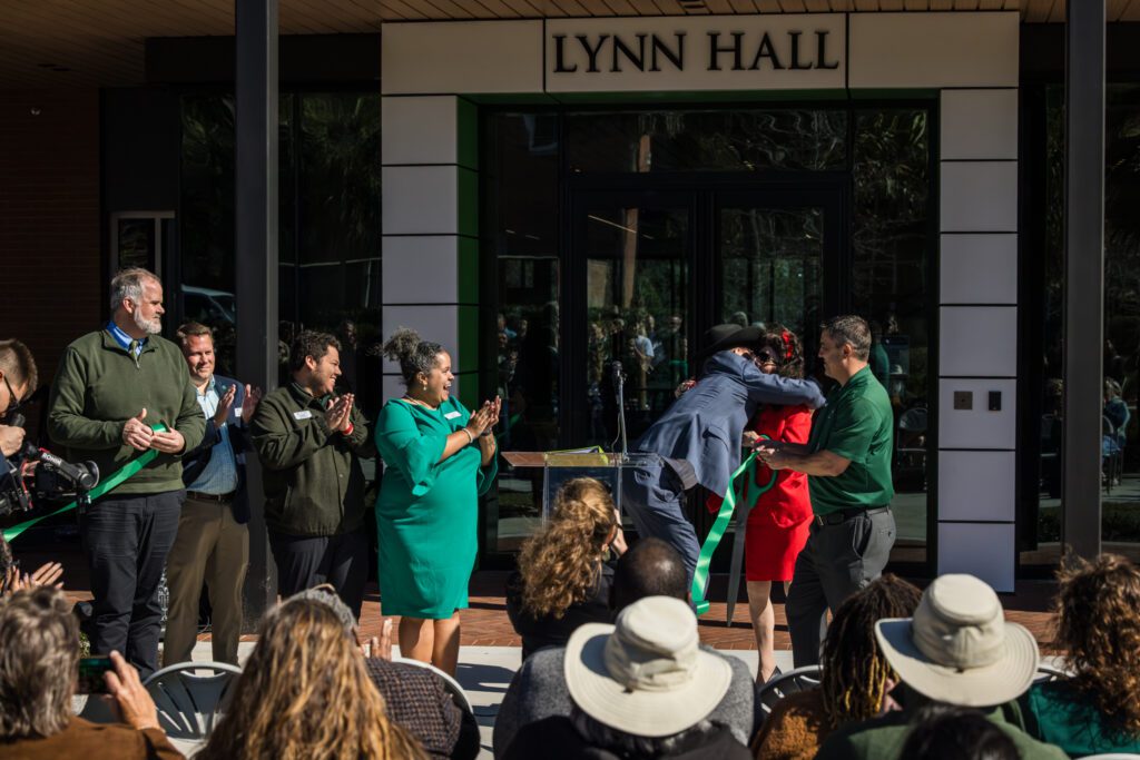 People celebrating outside Lynn Hall with applause and cheers.